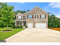 Charming two-story brick home with a well-manicured lawn and a spacious three-car garage at 3865 Rifflepool Ct, Douglasville, GA 30135