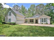 Charming two-story home features a well-maintained lawn, attached garage, and inviting curb appeal at 1709 Reese Rd, Sharpsburg, GA 30277