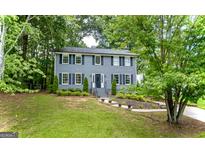 Charming two-story home featuring a well-manicured front yard and beautiful landscaping at 1875 Tree Brooke Ln, Snellville, GA 30078