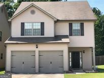 Charming two-story home featuring a two-car garage and a welcoming front entrance at 7609 Garnet Dr, Jonesboro, GA 30236