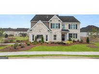 Charming two-story home with brick accents, landscaped yard, and welcoming front door at 687 Edgar St # 83, Hampton, GA 30228