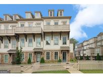 Charming townhouse with brick accents, balconies, and a white picket fence at 1100 Thomas St, Woodstock, GA 30188