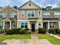 Inviting townhome showcasing manicured landscaping, a symmetrical design, and a welcoming front entrance at 6367 Ellenwood Drive, Rex, GA 30273