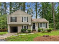 Charming two-story home features a landscaped front yard and attached one car garage at 447 Sherwood Cir, Stone Mountain, GA 30087