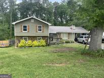 Charming two-story home with a metal roof, landscaped yard, and a covered carport for convenient parking at 1791 Little Fawn Nw Trl, Conyers, GA 30012