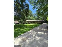 Lovely one-story home boasts a lush green lawn and long concrete driveway at 2527 Amalfi Dr, Conyers, GA 30012