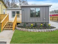 Charming home exterior with a new deck, manicured lawn, and colorful flowerbed at 1 Lamar Ave Sw, Atlanta, GA 30310