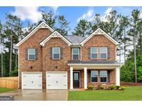 Beautiful two-story brick home featuring a welcoming entrance, manicured lawn, and two-car garage, perfect for Gathering living at 1184 Bluecoat Cir # 84, Hampton, GA 30228