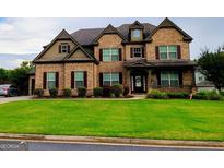 Charming two-story brick home with a manicured lawn and dark shutters at 206 Birchin Dr, Woodstock, GA 30188
