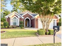 Charming brick home featuring a manicured front yard and a welcoming arched entryway at 121 Pinnacle Ln, Mcdonough, GA 30253