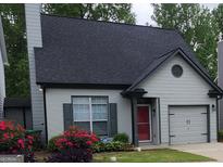 Charming home featuring a well-manicured lawn with vibrant flowering shrubs and a striking red front door at 1269 Gates Se Cir, Atlanta, GA 30316