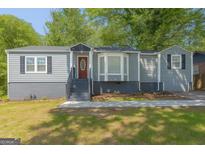 Charming single-story home featuring a red door, bay window, and gray siding at 1675 Brewer Sw Blvd, Atlanta, GA 30310