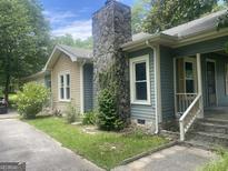 Cozy two-story home featuring a stone chimney and well-maintained landscaping at 212 Rockmart Rd, Villa Rica, GA 30180