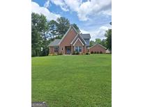 Charming brick home with a large front yard and lush landscaping, offering great curb appeal at 3612 Sierra Drive Dr, Stockbridge, GA 30281