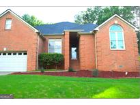 Charming all brick home featuring an attached garage and professionally landscaped yard at 122 Carolinas Way, Fayetteville, GA 30215