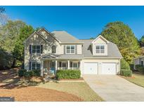 Charming two-story home with a two-car garage, blue front door, and well-maintained landscaping at 214 Palette Ln, Peachtree City, GA 30269