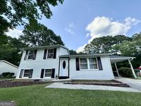 Charming two-story home with white siding, black shutters, and a well-maintained front lawn at 610 Tower Rd, Peachtree City, GA 30269