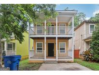 Charming two-story home with double porches and yellow siding, creating inviting curb appeal at 1159 Smith Sw St, Atlanta, GA 30310