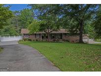 Charming brick ranch-style home with a well-manicured front lawn and mature trees at 183 Inman Rd, Fayetteville, GA 30215