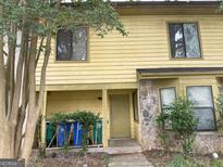 Townhouse exterior with siding and stone accents, featuring front door and a tree at 5908 Trent Jones Way, Lithonia, GA 30038