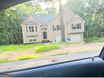 Traditional two-story home featuring a symmetrical design, complemented by a two-car garage and verdant surroundings at 4619 S Seminole Dr, Douglasville, GA 30135
