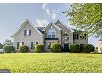 Charming brick home featuring a manicured lawn, lush landscaping, and a classic architectural design at 184 Fashion Xing, Mcdonough, GA 30252