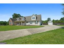 Charming home with a long drive and a detached garage, complemented by a spacious, well-manicured lawn at 603 Rossie Court, Mcdonough, GA 30252