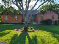 Charming single-Gathering home features a well-maintained lawn and mature trees that provide shade and curb appeal at 45 Oak Wood Lane, Covington, GA 30016