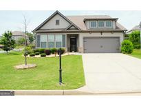 Charming single-Gathering home featuring a well-manicured lawn and an attached two-car garage at 4605 Dandelion Way, Cumming, GA 30040