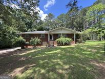 Charming single-story brick home with a covered front porch and a lush green lawn at 5277 Scofield Rd, South Fulton, GA 30349