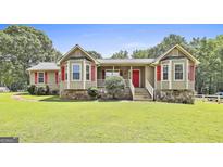 Charming single-story home featuring bay windows with red shutters and a lush front lawn at 100 Walnut Ct, Stockbridge, GA 30281