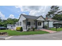 Well-maintained single-story home with a charming front porch, landscaped yard, and nearby neighborhood at 1 Hemlock, Porterdale, GA 30014