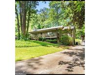 Charming home with a large front yard, mature trees, and a welcoming front porch at 4352 Treeline Way, Douglasville, GA 30135