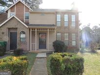 Charming townhome with a manicured front yard and inviting covered entryway at 883 Heritage Oaks Dr, Stone Mountain, GA 30088