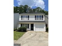 Charming two-story home with a garage, well-manicured lawn, and black shutters at 645 Stadler Pointe, Mcdonough, GA 30253