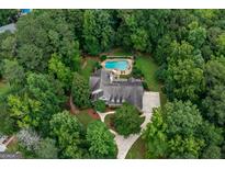 Stunning aerial view of a private estate with pool, lush landscaping, and circular driveway nestled among mature trees at 140 Silvermere, Fayetteville, GA 30215