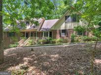 Charming brick home featuring a front porch and set amidst a lush, wooded landscape at 25 Ridgeview Dr, Jonesboro, GA 30236