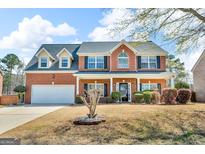 Charming two-story brick home with manicured lawn and attached two-car garage at 362 Interlake Pass, Mcdonough, GA 30252