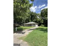 Charming single-story home nestled among lush trees with a long driveway at 1597 Joseph E Boone Nw Blvd, Atlanta, GA 30314