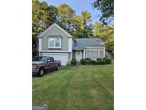 Charming home featuring a well-manicured lawn, attached garage, and inviting curb appeal at 620 Ashton Ln, Lawrenceville, GA 30044