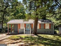 Charming single-story home featuring a welcoming front porch and attractive landscaping with mature trees at 130 Mount Zion Sw Rd, Atlanta, GA 30354