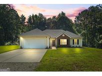 Charming home featuring a well-manicured lawn, complemented by a two car garage and brick facade at 315 Antioch Road, Mcdonough, GA 30252