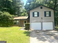 Two-story home featuring a two-car garage, brick accents, and lush green lawn at 4263 Southvale Dr, Decatur, GA 30034