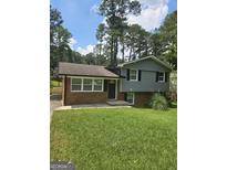 Charming house with a mix of brick and gray siding, complimented by a well-manicured lawn at 993 Roosevelt Se Dr, Atlanta, GA 30354