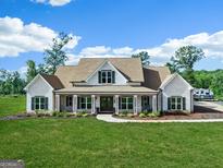 Charming, light brick home featuring a welcoming front porch and lush, green lawn at 357 Old Driver Rd, Whitesburg, GA 30185