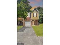 Traditional two-story home featuring brick and siding, attached garage, and well-manicured lawn at 755 Magnolia Gardens Walk, Mcdonough, GA 30253