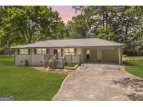 Charming brick home with a well-maintained lawn and a covered carport offers a welcoming curb appeal at 2164 Old Rex Morrow Rd, Morrow, GA 30260