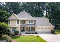 Charming two-story home featuring a spacious front porch, three-car garage, and beautifully landscaped front yard at 148 Lakeside Dr, Peachtree City, GA 30269