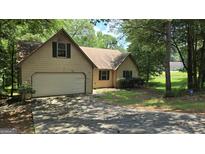 Charming home featuring an attached garage, mature trees and front yard at 1448 Se Hillside Place, Conyers, GA 30094