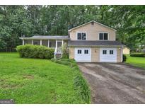 Charming two-story home features a screened porch, two-car garage, and a mature landscaped yard at 3681 Chestnut Lake Ct, Jonesboro, GA 30236